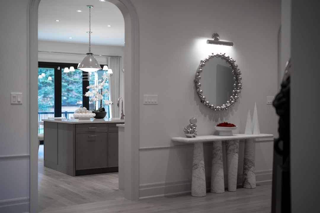 A smart speaker, like an Amazon Alexa or Google Home, sits on a console table in a bright, modern home entryway, symbolizing a voice-controlled smart home environment.
