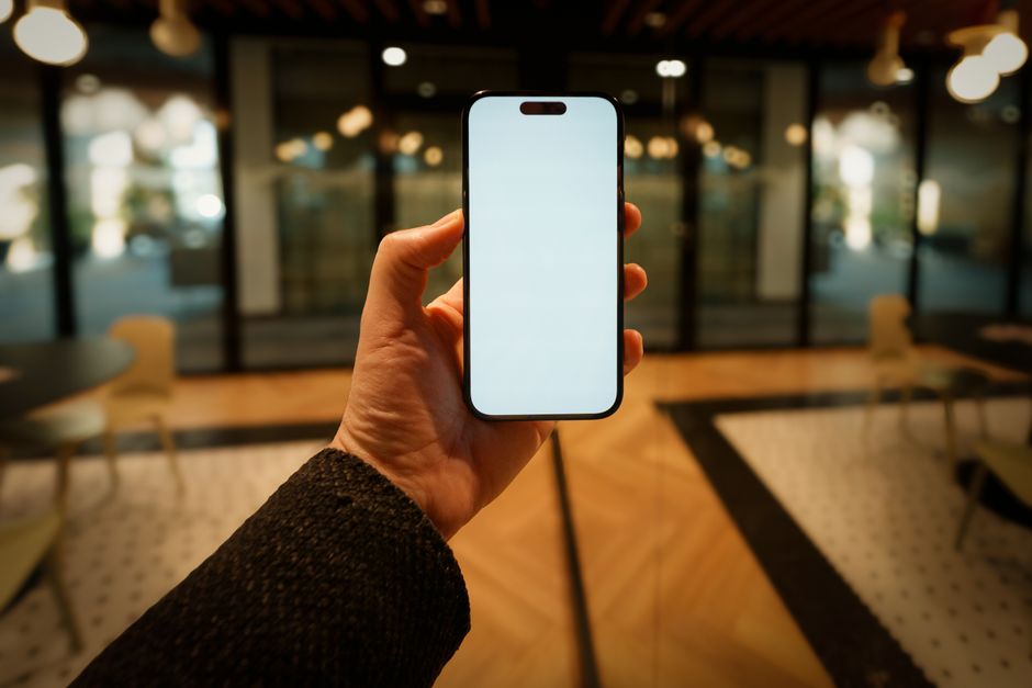 A close-up of hands holding a smartphone with a clean, futuristic interface, symbolizing the accessible and powerful AI tools available to modern businesses.