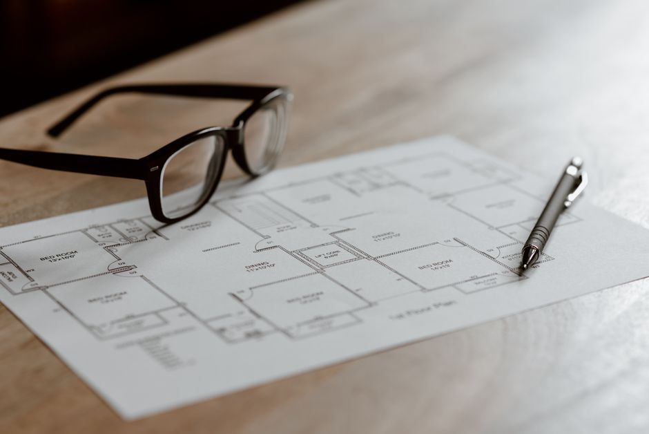A compass resting on a detailed architectural blueprint, symbolizing strategic planning and navigating risk in property investment.